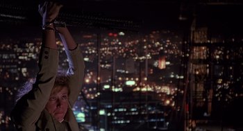 Movie still from “Darkman” (1990), directed by Sam Raimi – A woman standing in front of a window at night; Medium shot, Low angle