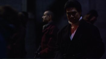 Movie still from “Darkman III: Die Darkman Die” (1996), directed by Bradford May – Two men are standing side by side in the dark; Medium shot, Low angle