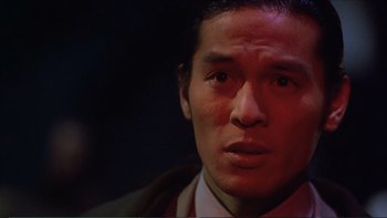 Movie still from “Darkman III: Die Darkman Die” (1996), directed by Bradford May – A person wearing a suit and tie; Close Up shot, Low angle