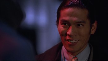 Movie still from “Darkman III: Die Darkman Die” (1996), directed by Bradford May – A person wearing a suit and tie; Close Up shot, Over the shoulder angle