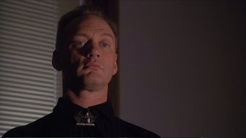 Movie still from “Darkman III: Die Darkman Die” (1996), directed by Bradford May – A person wearing a black shirt; Close Up shot, Low angle