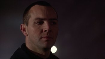 Movie still from “Darkman III: Die Darkman Die” (1996), directed by Bradford May – A person looking at the camera; Close Up shot, Low angle