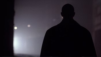 Movie still from “Darkman III: Die Darkman Die” (1996), directed by Bradford May – A man standing in front of the moon; Close Up shot, Low angle