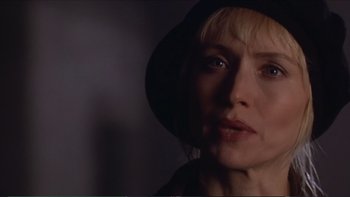 Movie still from “Darkman III: Die Darkman Die” (1996), directed by Bradford May – A person wearing a hat and looking at the camera; Close Up shot, Over the shoulder angle