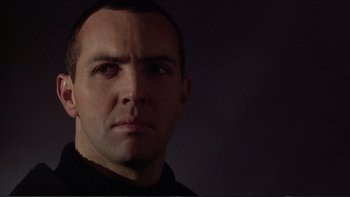 Movie still from “Darkman III: Die Darkman Die” (1996), directed by Bradford May – A person wearing a black shirt; Close Up shot, Low angle