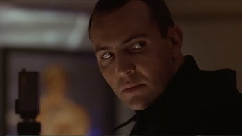 Movie still from “Darkman III: Die Darkman Die” (1996), directed by Bradford May – A person wearing a black shirt; Close Up shot, Low angle