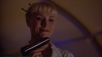 Movie still from “Darkman III: Die Darkman Die” (1996), directed by Bradford May – A woman holding a remote control in her hand; Close Up shot, Low angle