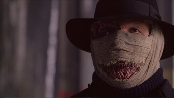 Movie still from “Darkman III: Die Darkman Die” (1996), directed by Bradford May – A man wearing a mask and a hat; Close Up shot, Low angle
