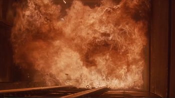 Movie still from “Darkman III: Die Darkman Die” (1996), directed by Bradford May – An image of an explosion in the middle of a road; Extreme Wide shot, Low angle