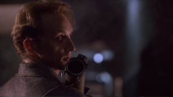 Movie still from “Darkman III: Die Darkman Die” (1996), directed by Bradford May – A man holding a video camera up to his face; Close Up shot, Low angle