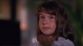 Movie still from “Darkman III: Die Darkman Die” (1996), directed by Bradford May – A little girl with blue eyes looking at the camera; Close Up shot, Over the shoulder angle