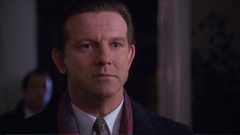 Movie still from “Darkman III: Die Darkman Die” (1996), directed by Bradford May – A person wearing a suit and tie; Close Up shot, Over the shoulder angle