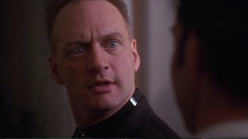 Movie still from “Darkman III: Die Darkman Die” (1996), directed by Bradford May – A person wearing a black shirt; Close Up shot, Over the shoulder angle