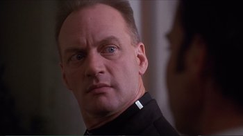 Movie still from “Darkman III: Die Darkman Die” (1996), directed by Bradford May – A person wearing a black uniform; Close Up shot, Low angle