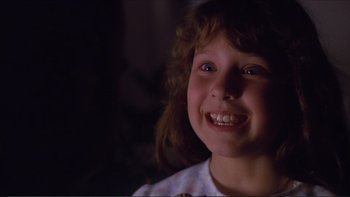 Movie still from “Darkman III: Die Darkman Die” (1996), directed by Bradford May – A young girl smiling for the camera with her mouth wide open; Close Up shot, Low angle
