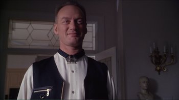 Movie still from “Darkman III: Die Darkman Die” (1996), directed by Bradford May – A man in a white shirt and black vest; Close Up shot, Low angle