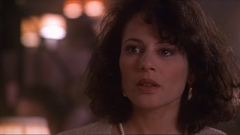 Movie still from “Darkman III: Die Darkman Die” (1996), directed by Bradford May – A person wearing a necklace; Close Up shot, Over the shoulder angle