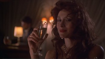 Movie still from “Darkman III: Die Darkman Die” (1996), directed by Bradford May – A beautiful woman holding a glass of wine; Close Up shot, Low angle