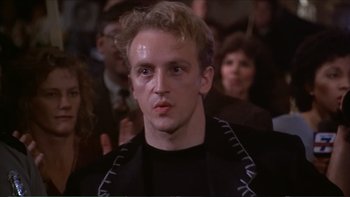 Movie still from “Darkman III: Die Darkman Die” (1996), directed by Bradford May – A person with a crowd in the background; Close Up shot, Low angle