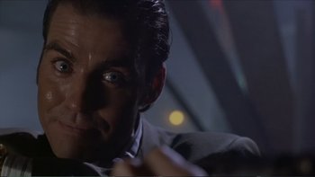 Movie still from “Darkman III: Die Darkman Die” (1996), directed by Bradford May – A person wearing a suit and tie; Close Up shot, Low angle