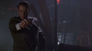 Movie still from “Darkman III: Die Darkman Die” (1996), directed by Bradford May – A man in a suit holding a knife in his hand; Close Up shot, Low angle