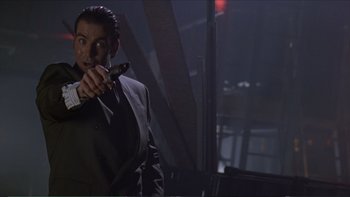 Movie still from “Darkman III: Die Darkman Die” (1996), directed by Bradford May – A man in a black suit holding a cell phone in his hand; Close Up shot, Low angle
