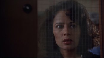 Movie still from “Darkman III: Die Darkman Die” (1996), directed by Bradford May – A person looking through a window; Close Up shot, Low angle