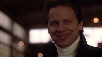 Movie still from “Darkman II: The Return of Durant” (1995), directed by Bradford May – A person smiling for a picture; Close Up shot, Low angle