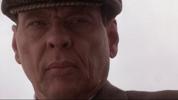 Movie still from “Darkman II: The Return of Durant” (1995), directed by Bradford May – A man in a hat and suit is looking at the camera; Close Up shot, Low angle