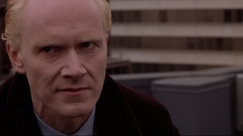 Movie still from “Darkman II: The Return of Durant” (1995), directed by Bradford May – A man with blonde hair wearing a suit and tie; Close Up shot, Low angle