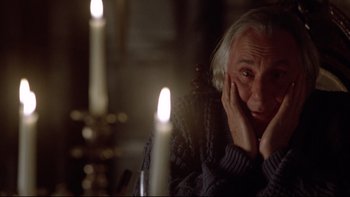 Movie still from “Darkman II: The Return of Durant” (1995), directed by Bradford May – An older man sitting in front of a lit candle; Close Up shot, Low angle