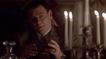 Movie still from “Darkman II: The Return of Durant” (1995), directed by Bradford May – A man in a suit and tie holding a glass of wine; Close Up shot, Low angle