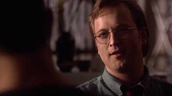 Movie still from “Darkman II: The Return of Durant” (1995), directed by Bradford May – A person wearing glasses and a tie; Close Up shot, Over the shoulder angle