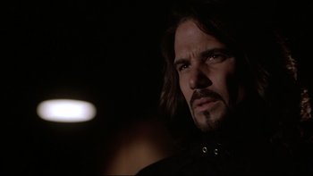 Movie still from “Darkman II: The Return of Durant” (1995), directed by Bradford May – A person with long black hair; Close Up shot, Over the shoulder angle