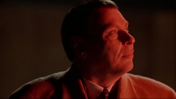 Movie still from “Darkman II: The Return of Durant” (1995), directed by Bradford May – A person wearing a suit and tie; Close Up shot, Low angle