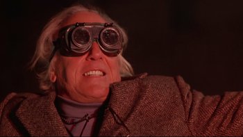 Movie still from “Darkman II: The Return of Durant” (1995), directed by Bradford May – An older man wearing a pair of binoculars; Close Up shot, Low angle