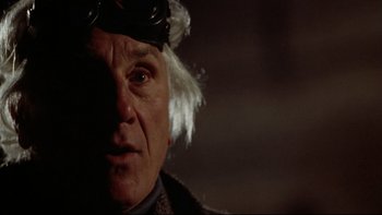 Movie still from “Darkman II: The Return of Durant” (1995), directed by Bradford May – An older man with a white wig on his head; Close Up shot, Low angle