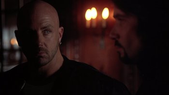 Movie still from “Darkman II: The Return of Durant” (1995), directed by Bradford May – A man with a shaved head is looking at another man with a shaved head; Close Up shot, Over the shoulder angle