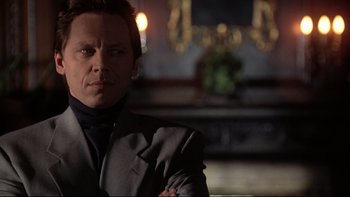 Movie still from “Darkman II: The Return of Durant” (1995), directed by Bradford May – A person wearing a suit and tie; Close Up shot, Low angle