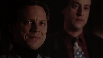 Movie still from “Darkman II: The Return of Durant” (1995), directed by Bradford May – Two men in suits and ties are looking at the camera; Close Up shot, Low angle