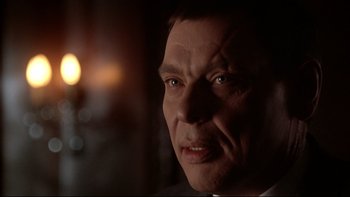 Movie still from “Darkman II: The Return of Durant” (1995), directed by Bradford May – A man's face in a dark room; Close Up shot, Over the shoulder angle