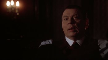 Movie still from “Darkman II: The Return of Durant” (1995), directed by Bradford May – A person wearing a suit and tie; Close Up shot, Over the shoulder angle