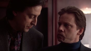 Movie still from “Darkman II: The Return of Durant” (1995), directed by Bradford May – Two men in business suits talking to each other; Close Up shot, Over the shoulder angle