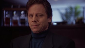 Movie still from “Darkman II: The Return of Durant” (1995), directed by Bradford May – A person wearing a suit and tie; Close Up shot, Low angle