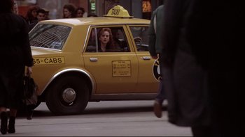 Movie still from “Darkman II: The Return of Durant” (1995), directed by Bradford May – A woman sitting in the driver's seat of a yellow taxi cab; Wide shot, Over the shoulder angle