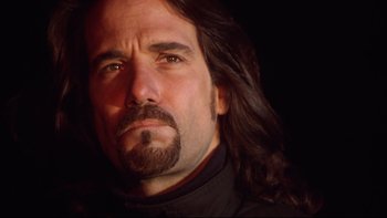 Movie still from “Darkman II: The Return of Durant” (1995), directed by Bradford May – A person with long hair and a beard; Close Up shot, Low angle