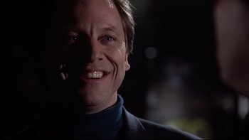 Movie still from “Darkman II: The Return of Durant” (1995), directed by Bradford May – A person with a smile on their face; Close Up shot, Low angle