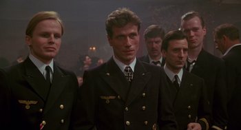 Movie still from “Das Boot” (1981), directed by Wolfgang Petersen – A group of men standing next to each other in suits; Medium shot, Low angle