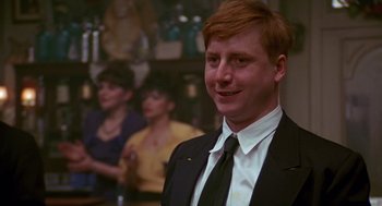 Movie still from “Das Boot” (1981), directed by Wolfgang Petersen – A man in a suit and tie smiling for the camera; Close Up shot, Low angle