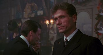 Movie still from “Das Boot” (1981), directed by Wolfgang Petersen – A man in a suit and tie standing next to another man in a suit and tie; Close Up shot, Over the shoulder angle